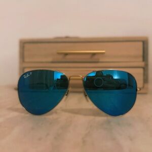 Ray Bans polarized aviator sunglasses with gold frame and blue mirrored lenses.